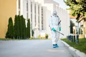 Tecnico effettua una disinfestazione di formiche in un'area pubblica